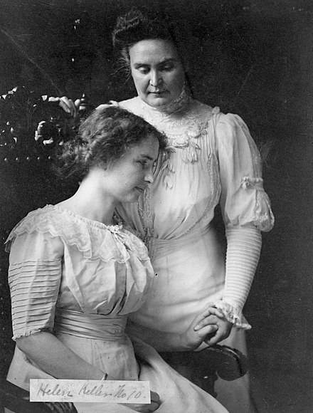 Sullivan (standing) with Helen Keller, c. 1909