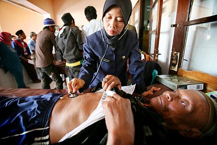 A nurse in Indonesia examining a patient
