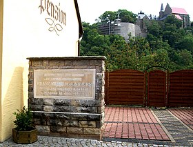 Im Vordergrund die Gedenktafel. Im Hintergrund das Mansfelder Schloss