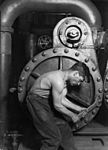 Power house mechanic working on steam pump. En arbetare vid en ångpump, 1920.