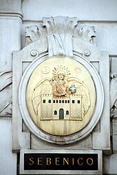 Wappen von Šibenik auf dem einst von der Marinesektion des k.u.k. Kriegsministeriums genutzten Amtsgebäude Marxergasse 2 in Wien. Im amtlichen Gebrauch der k.u.k. Marine wurden die Namen in italienischer Sprache verwendet.