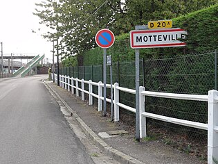 莫特維爾入城路牌和後方的火車站人行橋