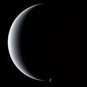 Neptuno y la mayor de sus lunas, Tritón -abajo, centro, pequeña-, en una imagen tomada por la Voyager 2 en 1989. (NASA APOD)