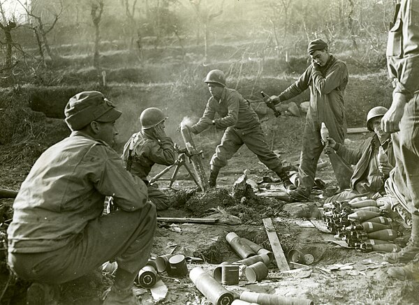 G.I.'s of the 141st Infantry, 36th Infantry Division, firing an 81-mm. mortar in support of the Rapido river crossing, January 1944.