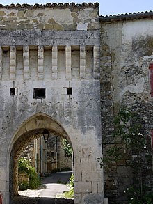 Porte en pierre de taille, voûte du portail en ogive, passage voûté en berceau. Il reste des mâchicoulis, le crénelage a disparu, remplacé par un mur supportant un toit.