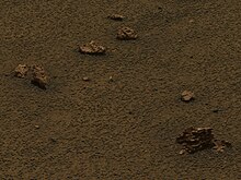 Figure 17. Detail showing hematite spherules eroding out of blocks of sediment ejecta. Notice the increased surface density of loose spherules lying in rings around the small clocks of sediment ejecta. This image is cropped from Figure 7. It was taken on Sol 1162 (2007-0501). Sol1162B.Rim.Victoria.Crater.and.plain.at.Meridiani.Planum.ejecta.decay.detail.jpg