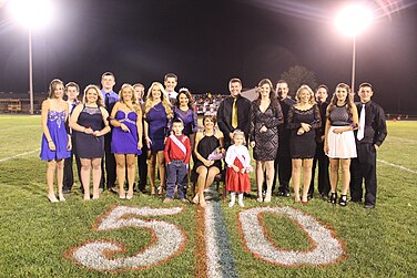 Die Homecoming Queen, Kandidaten und Begleitpersonen von South Shelby aus dem Jahr 2015 machen während der Halbzeit des Fußballspiels auf der 50-Yard-Linie Fotos.