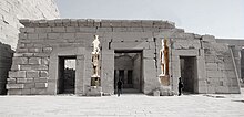 Great courtyard with entrance to the chapels of the sacred boats of Seti II, with the reconstruction of the location of the large statue of the pharaoh now at the Museo Egizio of Turin (on the left) and of another similar (right) at the Louvre. Statue of Seti II, sandstone - Museo Egizio Turin C 1383 p013.jpg