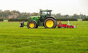 zijaanzicht van diepwoeler achter tractor op een weide