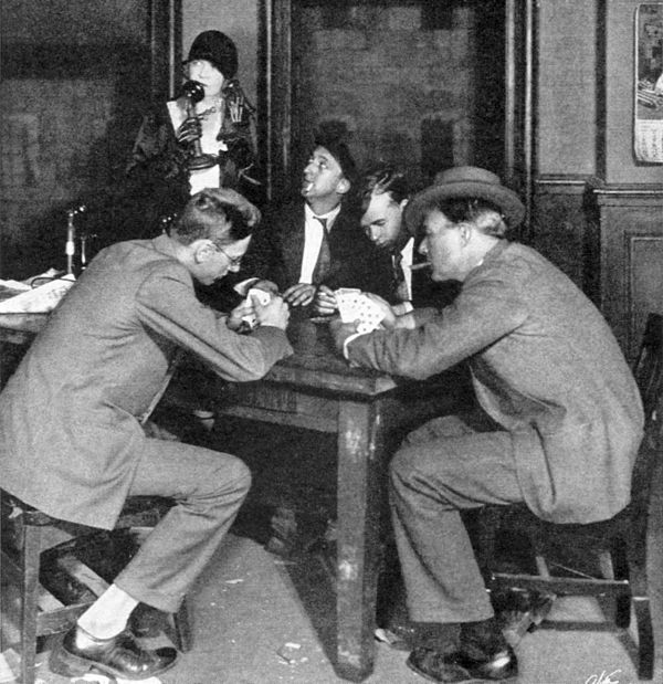 Reporters play cards in the press room of the Criminal Courts Building in Act I of The Front Page (1928)