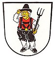 Gemeinde Schlottenhof In silber ein bärtiger Bauer in der Tracht des Sechsämterlandes mit hohem schwarzen Spitzhut, schwarzer Hose, schwarzen Hosenträgern, schwarzen Pantoffeln, rotem Wams, silbernem Hemd und silbernen Strümpfen, in der Linken eine schwarze Mistgabel haltend.