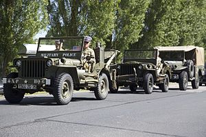 Машина военной полиции во главе праздничной мехколонны по случаю 71-й годовщины высадки в Нормандии.