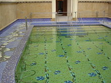 Fotografía en color de una antigua piscina termal pública.