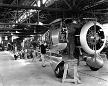 Assembly line at the beginning of Staggerwing production; the sole A17F (with fixed landing gear) is being constructed in front of the frames of the first and second production B17Ls. Beechcraft Staggerwing production line.jpg