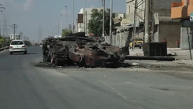 A destroyed government tank on a road in Aleppo