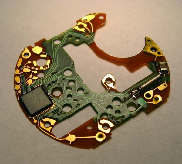 Circuit board of an e block from a chronograph-wristwatch. Quartz oscillator crystal on right.