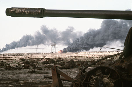 Disabled Iraqi T-54A, T-55, Type 59 or Type 69 tank and burning Kuwaiti oil field.jpg