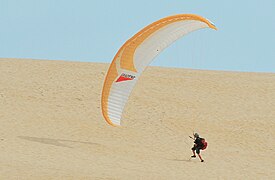 Un parapentiste gonfle sa voile sur la dune du Pilat.