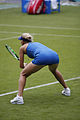Elena Vesnina waiting to receive a serve in partial squatting position.