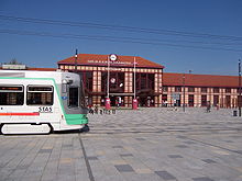 Der Eingang zum Bahnhof mit der Durchfahrt einer Straßenbahn