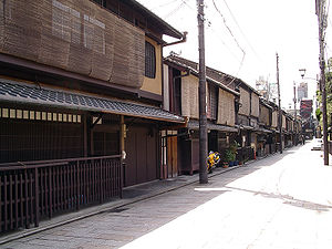 Wooden two-storied houses lining a small street. The upper stories