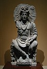 Maitreya, assegut en un tron a la manera occidental, amb el devot de Kushan. Segle II Gandhara.