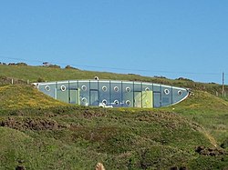 A glass structure, built into a hilltop.