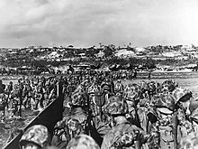 The 6th Marine Division wade ashore to support the beachhead on Okinawa, 1 April 1945. Marines land on Okinawa shores.jpg