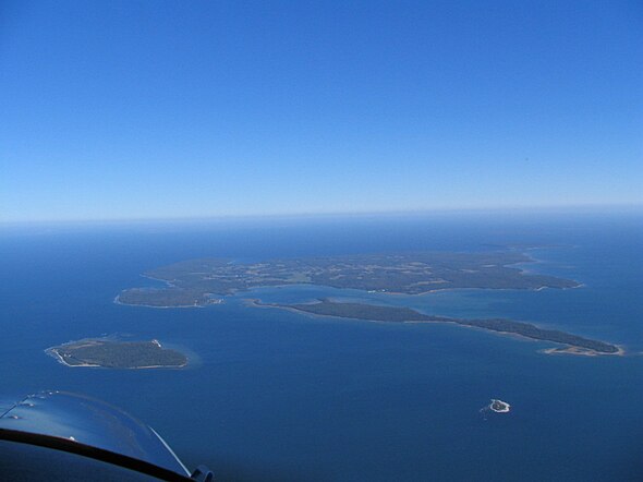 Pilot Island is the small island at the lower right, with the larger Plum Island is at the lower left. Above Pilot Island is the long and narrow Detroit Island, with Washington Island in the distance.