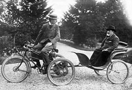 De Dion-Bouton tricycle towing a passenger in a carriage