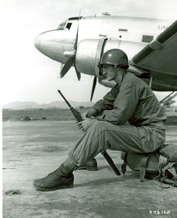 A soldier of the 24th Infantry Division waits to board a plane bound for Korea in 1950.