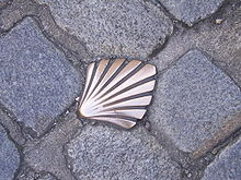 fotografia de uma vieira de cobre inserida nos paralelepípedos de uma rua de Limoges e marcando a passagem da Via Lemovicensis que leva a Santiago de Compostela