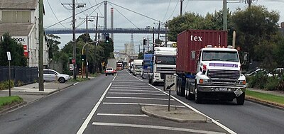 Heavy vehicles at the southern end of Whitehall Street, which would form part of the West Gate Distributor route to the Port of Melbourne. The West Gate Bridge is in the background. Westgate whitehall.jpg