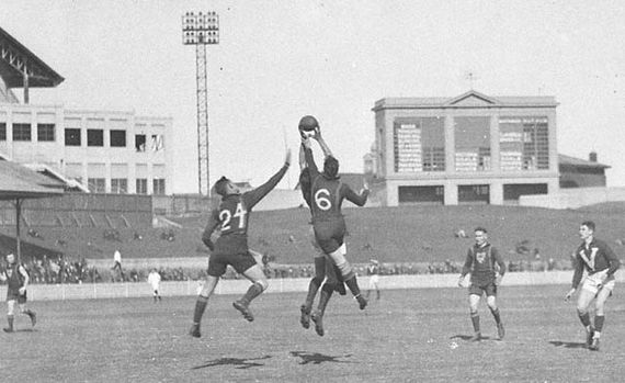Players contest a mark at the Australian Football Carnival, in 1933, at the Sydney Cricket Ground. The teams are Victoria and Tasmania. (Photographer: Sam Hood.)