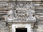 Statue of Batara Kala with horns and fangs above the door of a temple