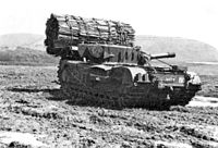 A tank with bundle of wooden stakes in front of it