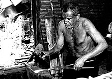 A blacksmith using pliers Ferreiro ou metalurgico tradicional.jpg