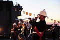A cornet player performing on a posthorn during a reception aboard the RFA Argus (A135) in Baltimore's inner harbor.