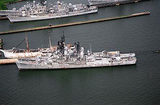 An aerial side view of two Forrest Sherman-class destroyers tied up at the Baltimore Fairfield Terminal awaiting scrapping. Inboard is the destroyer ex-USS Forrest Sherman (DD-931) and outboard is the ex-USS Blandy (DD-943). On the north side of the pier is the former U.S. Army N-3 type port repair ship Madison Jordan Manchester, also scheduled for scrapping. Forrest Sherman and Charles F. Adams-class destroyers awaiting scrapping in Baltimore, Maryland (USA), 25 August 1994 (6490446).jpg