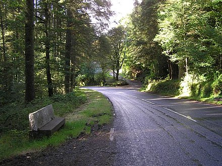 Gortin Road. Heading south-west towards Omagh; to the left is the "Rest and be thankful" bench.