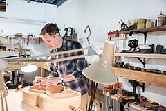 Environmental portrait of guitar luthier Guitar Luthier in Workshop.jpg