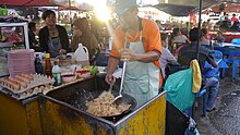 A cook making nasi goreng in a food market in Kota Kinabalu, Sabah. Kota Kinabalu food market.jpg