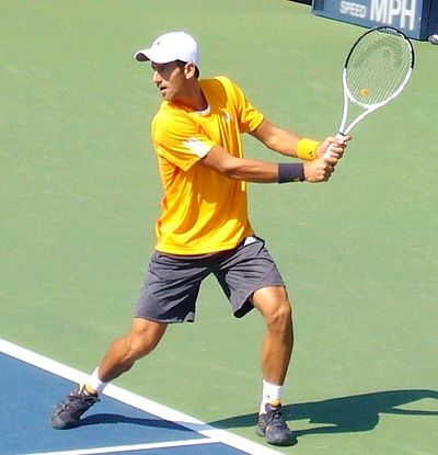 Novak Djokovic in a two-handed backhand motion.