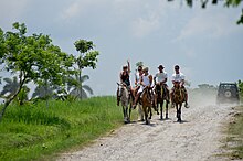 Photo of a group of white riders, seen from the front.