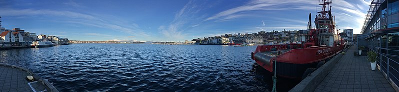 File:Stord harbour, Leirvik, Norway. Nattrutekaien, "Tranen" catamaran ferry, Evjo, "BB Coaster" tug boat. Hamnegata, Teinevika, Oma Slipp, etc. Compressed, distorted panorama 2018-03-10.jpg