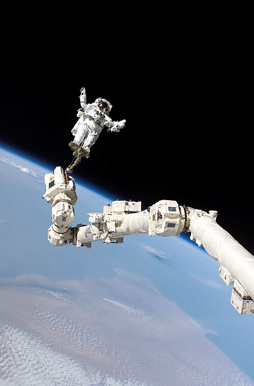 Stephen Robinson riding the Canadarm2 during STS-114 on August 3, 2005. The first in-flight repair of the Space Shuttle. The landmass in the backdrop 