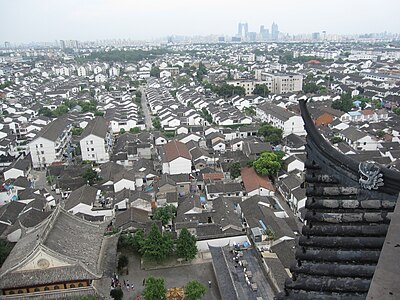 A view of the old city of Suzhou atop the Ming Dynasty Beisi Pagoda, Bao'en Temple. The photo was taken in July 2012 with the Central Business District of the city in the distance (amongst the cluster of buildings the then-under construction Gate to the East