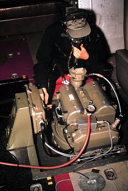 Aerial photographer in the unpressurized cabin of a NOAA de Havilland Buffalo breathing with the assistance of an oxygen mask while operating a Wild H