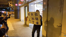 A man held a placard 'Ng Kin-wai still missing' Yuen Long Station people show message 20210321.png