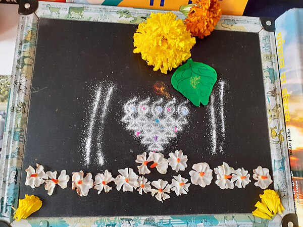 Saraswati puja on Vijayadashami in Maharashtra with symbolic drawing (yantra) of the goddess on a slate.